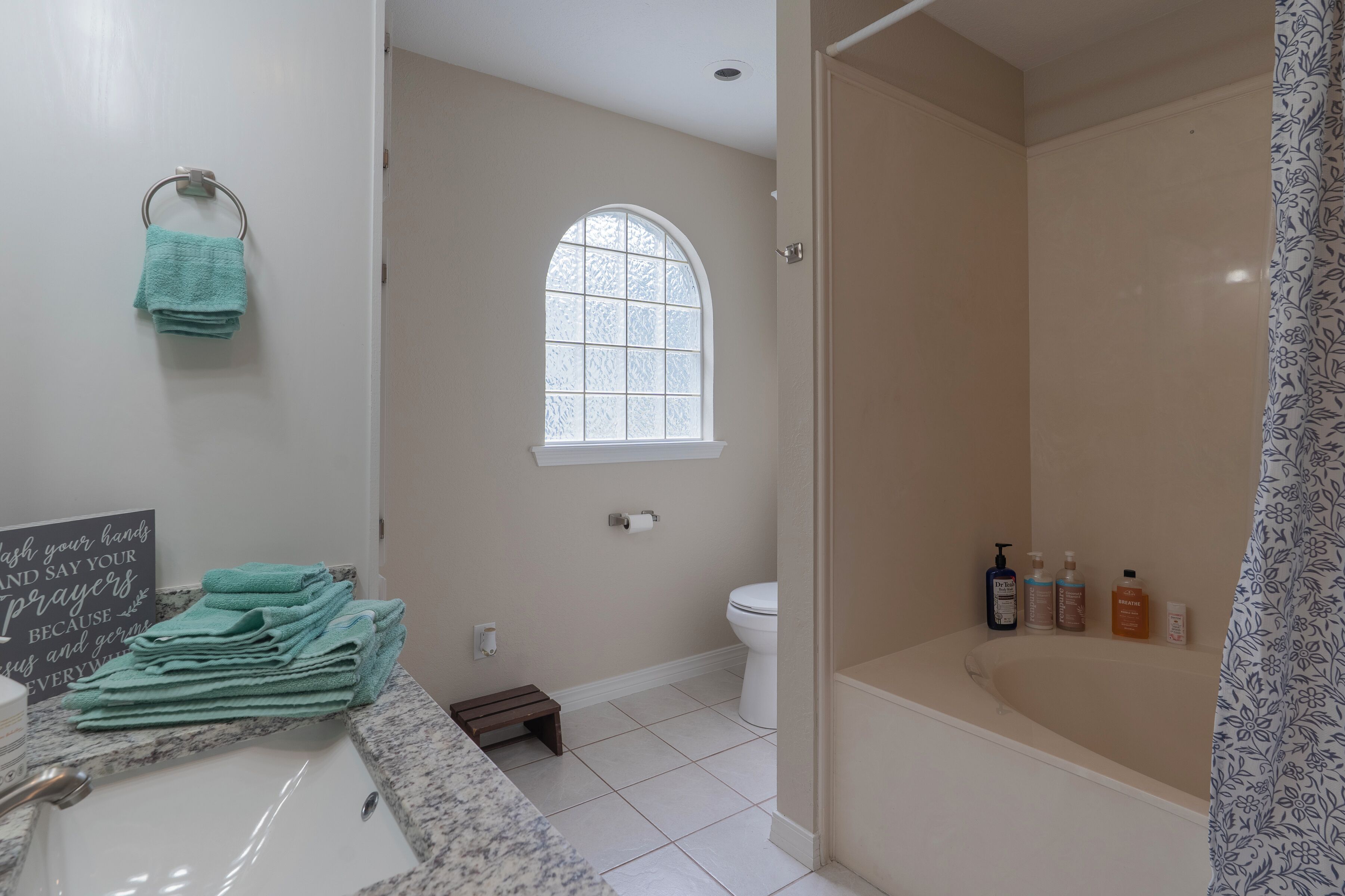Un baño con lavamanos, inodoro, ducha y ventana.
