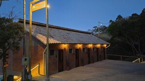 A building with a sign reading 'Villa da Serra,' a brick exterior, and a series of windows. - Villa da Serra Suites (Lima Duarte)