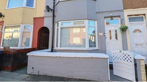 A row of terraced houses with bay windows, white doors, and a brick wall in front. - LATE CHECK-OUT AVAILABLE<br>We offer a 20% discount for all stays of 28+ nights and 10% discount for all stays of 7+ nights. Discounted rate is automatically applied and includes all utility bills and bi-weekly professional cleaning. No hidden fees. (Anfield)