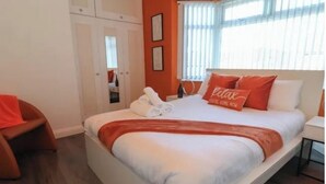 A bedroom with a bed, a chair, and a wardrobe. - LATE CHECK-OUT AVAILABLE<br>We offer a 20% discount for all stays of 28+ nights and 10% discount for all stays of 7+ nights. Discounted rate is automatically applied and includes all utility bills and bi-weekly professional cleaning. No hidden fees. (Anfield)