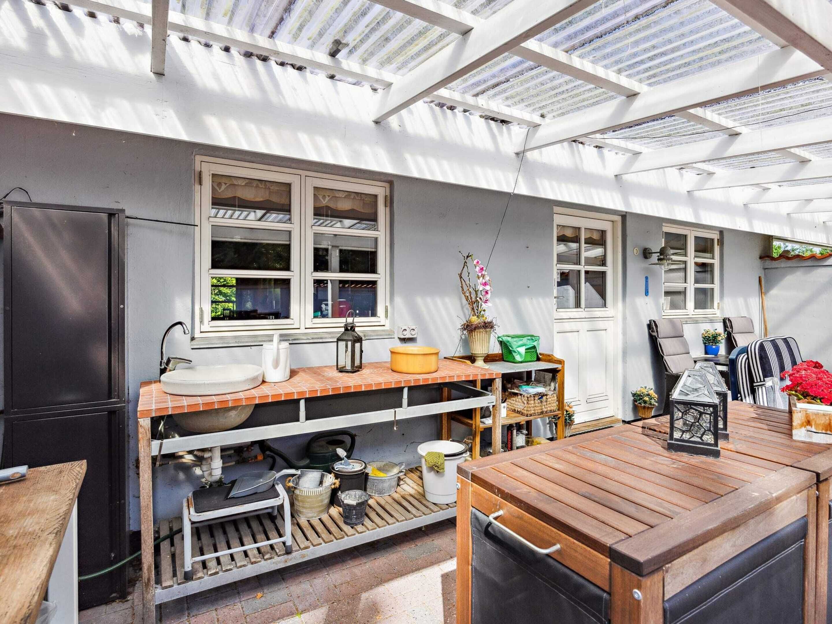 A compact kitchen with a wooden countertop, a sink, and a window overlooking a garden.