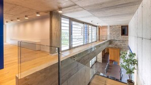 Un intérieur spacieux avec un plafond haut, de grandes fenêtres et un design moderne.