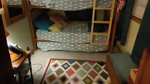 A bunk bed room with a desk and a patterned rug. - Charming 2-bedroom cabin on lake near Duluth MN with Air Conditioning (Saginaw)