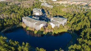 A large, multi-story building with a central courtyard and a lake.