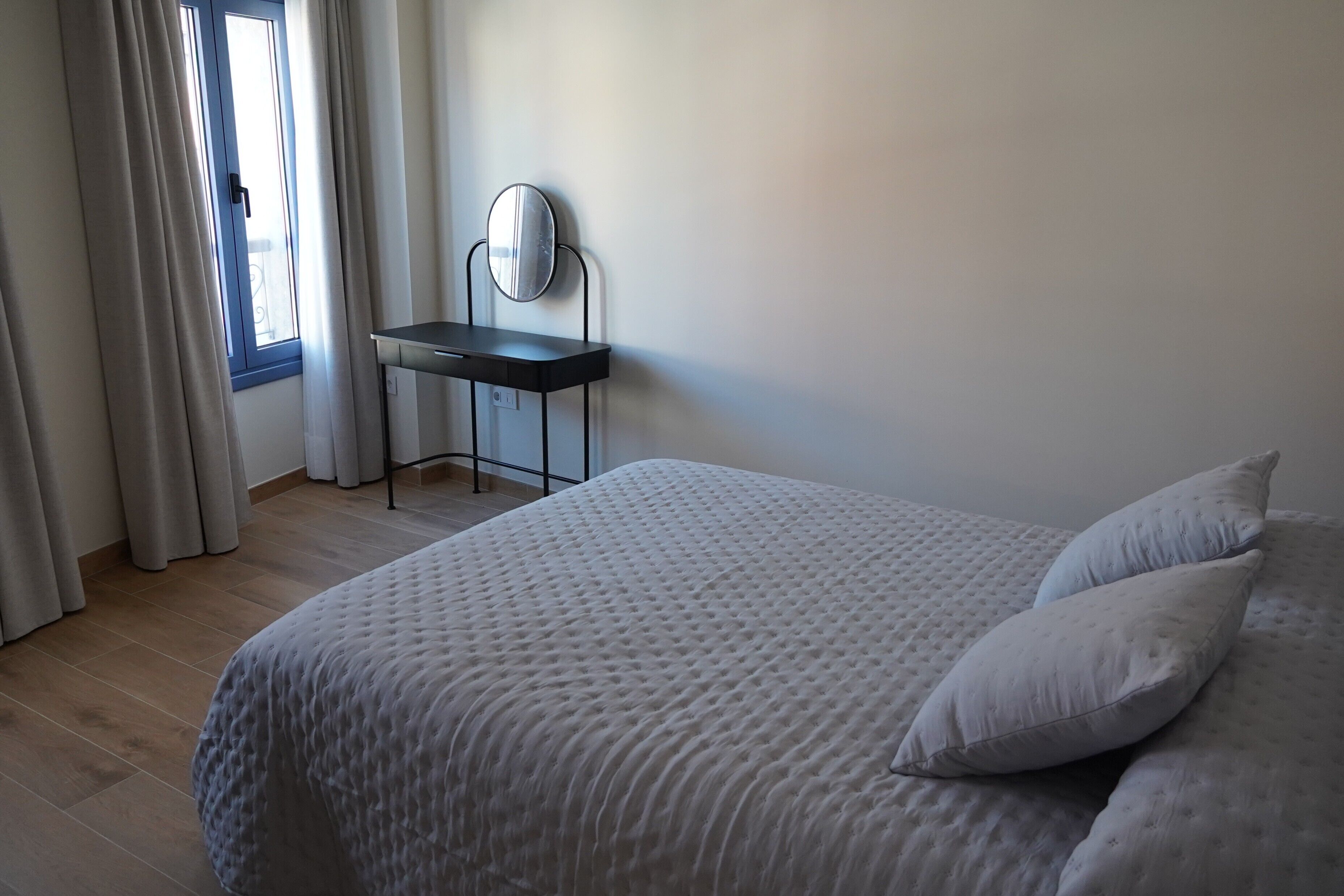Una camera da letto con un letto, una scrivania e una finestra con tende.