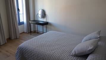 Una camera da letto con un letto, una scrivania e una finestra con tende.