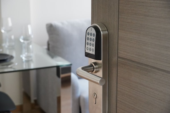 A modern door with a keyhole and a numeric keypad lock. - VILLAGRADO Suites AT3LLaves (Grado)