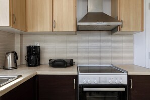 A kitchen with wooden cabinets, a stainless steel range, a coffee maker, and a toaster.