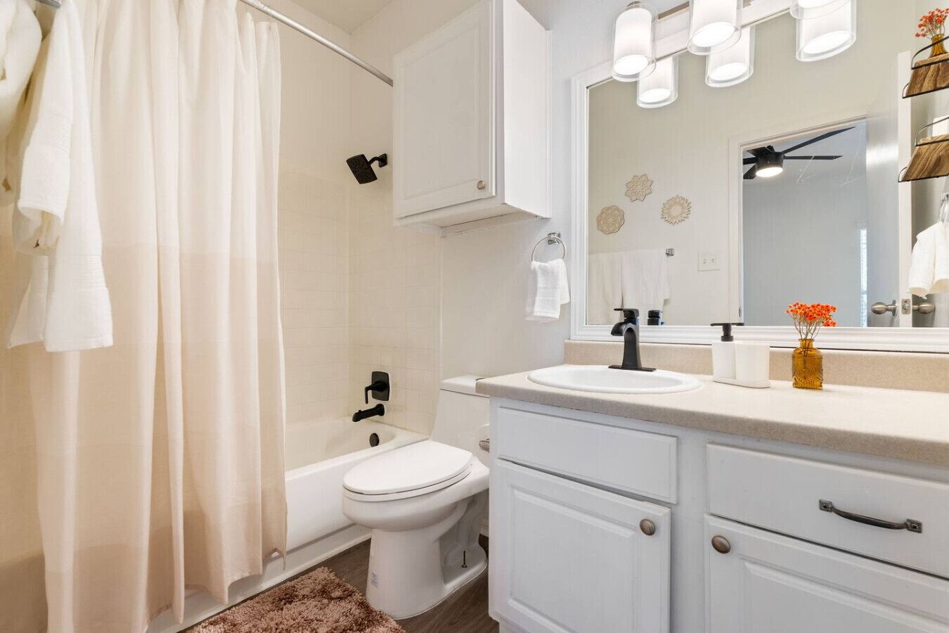A modern bathroom with a shower, toilet, sink, and vanity.