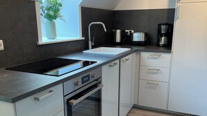 A modern kitchen with a skylight, stainless steel appliances, and light-colored cabinetry. - Hermine vacation apartment with far-reaching views of nature (Soltau)