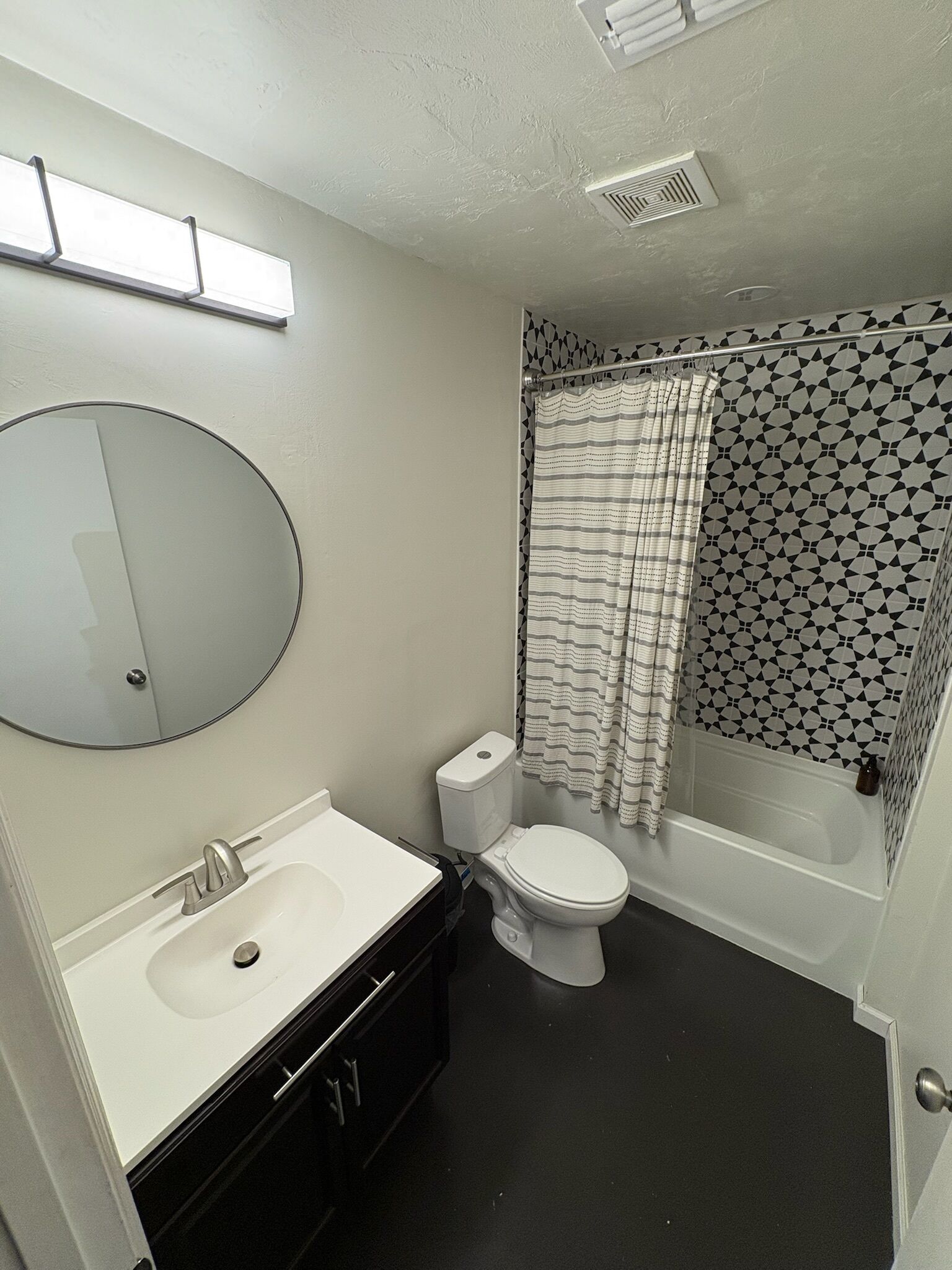 Een badkamer met toilet, wastafel en bad.