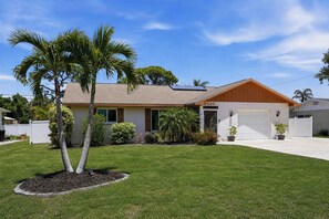 A single-story house with a garage, solar panels, and a well-maintained lawn. - Sunset Beach Retreat w/Pool - 8 mins to Beach (Venice)