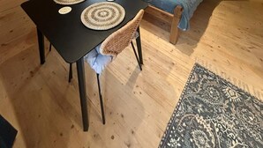 Une pièce confortable avec un lit, une table avec des sets de table, une fenêtre avec des rideaux et une table de chevet avec une lampe.