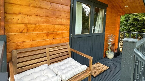 Une terrasse en bois avec un banc et une porte.