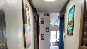 A hallway with wooden flooring, white walls, and various Yellowstone-themed posters. - Livingston MT Paradise Unit B (Livingston)