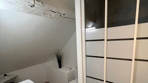 A small, modern bathroom with a white sink, toilet, and shower enclosure. - Cosy furnished studio in a quiet location near the Cathedral (Orléans)