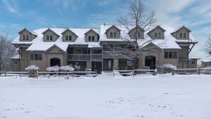 A large, multi-story building with a symmetrical facade, multiple windows, and a snow-covered roof.