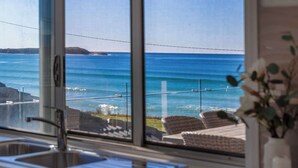 Una cocina con un ventanal que da a la playa.