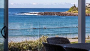 A view of the ocean from a window with a chair in the foreground. - Seabreeze on the Beach "Feng" (Warilla)