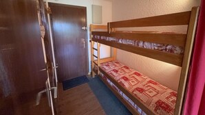A bunk bed room with a wooden door and a small ladder. - 100m from ski slopes, 2nd floor, view ski slopes, terrace, tv, ski locker, 24m², Les Saisies (Les Saisies)