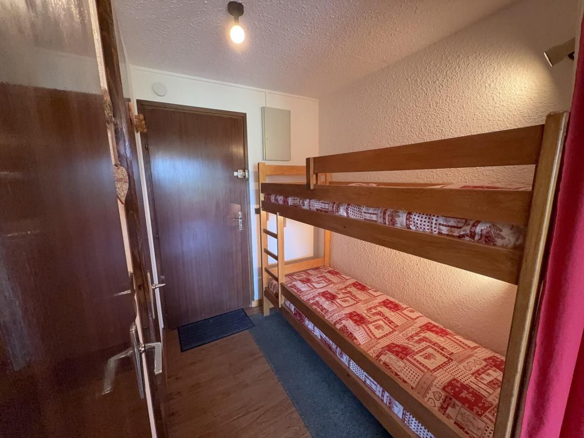 A bunk bed room with a wooden door and a small ladder.