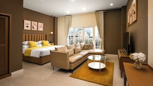 A modern hotel room with a bed, sofa, TV, and a large window with curtains. - Ali Grand Hotel (Vientiane)