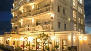 A multi-story hotel with a grand entrance, multiple balconies, and a well-lit facade. - Ali Grand Hotel (Vientiane)