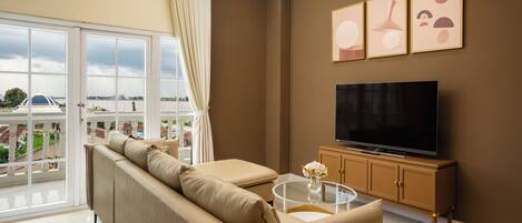 Ein Wohnzimmer mit Sofa, Fernseher und Kunstwerk an der Wand.