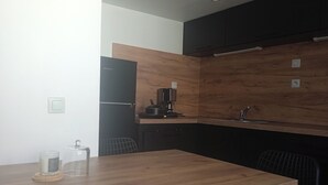 A modern kitchen with a wooden countertop, a coffee machine, and a refrigerator. - Le Duplex d'Abi, quiet, overlooking courtyard, close to the center of Saint Étienne (Saint-Étienne)