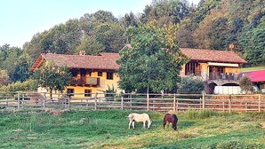 A rural setting with a fenced pasture, a yellow house with a red roof, and a stone bridge. - Wonderful property in a fantastic location. Family-friendly. Il Roseto I (Somano)