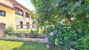 A traditional building with a stone facade, a wooden fence, and a garden with pink flowers and green foliage. - Wonderful property in a fantastic location. Family-friendly. Il Roseto I (Somano)