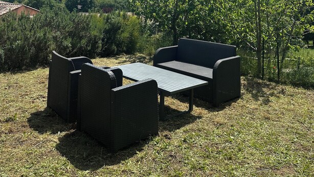 An outdoor seating area with a table and chairs, surrounded by greenery and a view of a hilly landscape. - Charming T1 bis apartment in Collobrières (Collobrières)