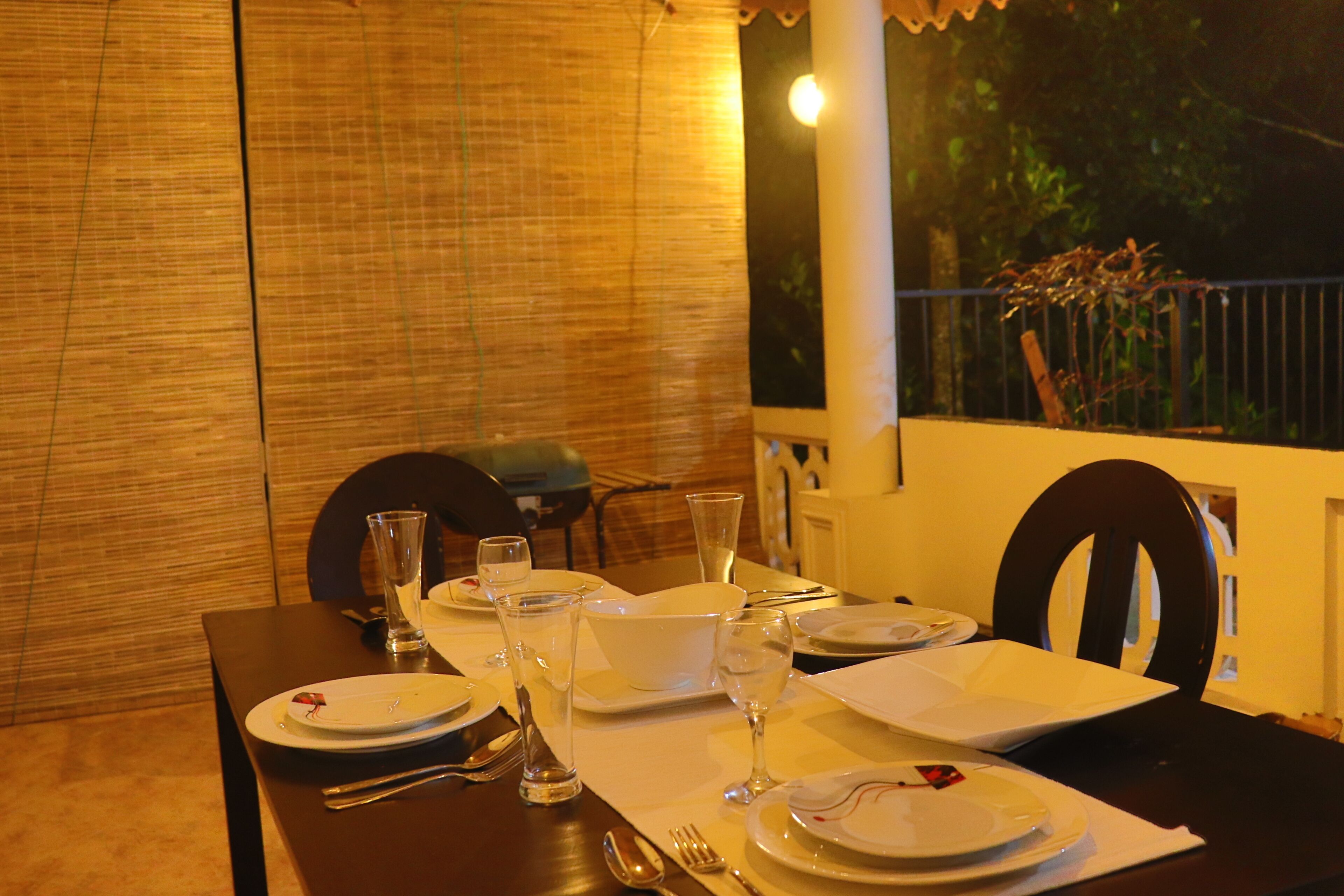 A dining table set for four with plates, cutlery, and glasses.
