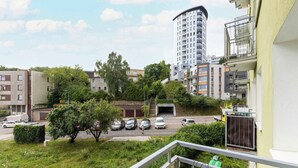 Asuinalue, jossa on kerrostalo, useita autoja sisältävä pysäköintialue ja viheralue, jossa on puita.