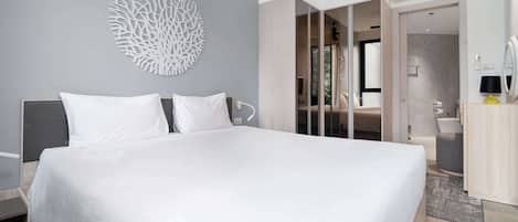Une chambre à coucher moderne avec un grand lit, un élément décoratif mural et un dressing.