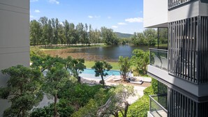 Edifici modern amb piscina i vista d'un llac envoltat d'arbres.
