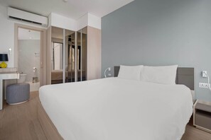 A modern hotel room with a large bed, a bedside table, a small stool, a mirror, and a walk-in closet. - Cassia Residences, One Bedroom 1403 A Deluxe Lake (Choeng Thale)