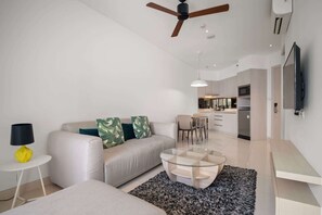 Un salon moderne avec un canapé, une table basse et un ventilateur de plafond.