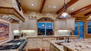 A kitchen with white cabinets, a stove, and a window with a view. - NEW LISTING…Spectacular Fallbrook Custom Estate on 2 acres with incredible views (Fallbrook)