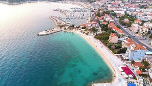An aerial view of a coastal town with a marina, sandy beach, and residential buildings. - B apt w Terrace & sea View, 4 min Walk to Beach (Podstrana)