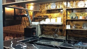A kitchen with a marble countertop, wooden wall paneling, and various kitchenware on shelves. - Your Second Home Awaits – Cozy Stay with Outstanding Service (Agadir)