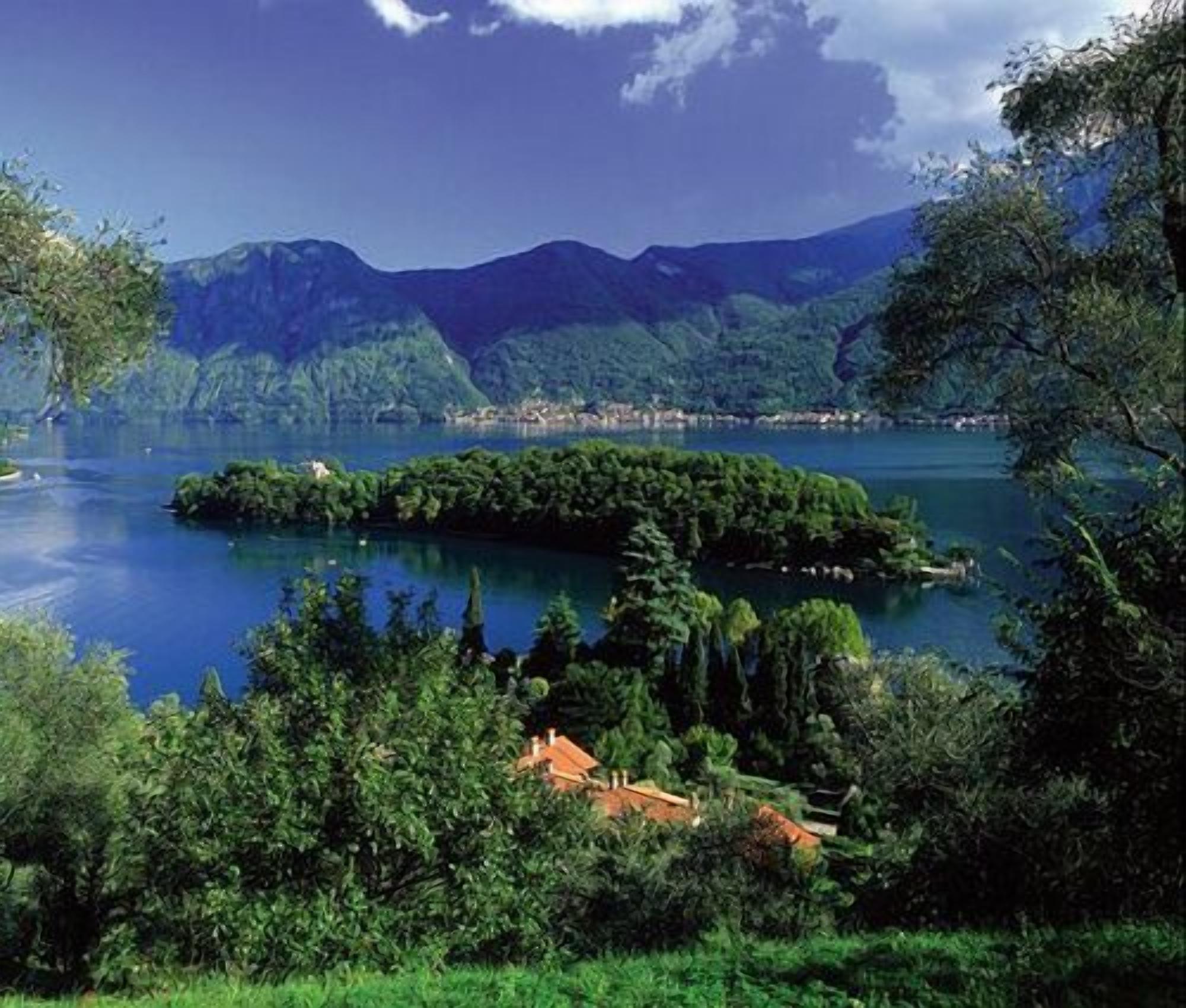 A lake surrounded by lush greenery and mountains in the background.