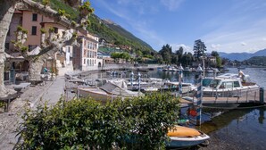 Un puerto deportivo con barcos amarrados, un sendero de piedra y edificios con balcones con vista al agua.