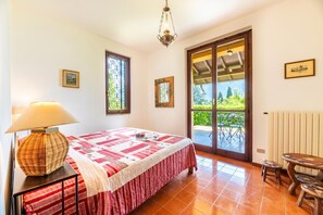 Une chambre Ă coucher avec un lit, une lampe, une fenĂȘtre et une vue sur lâextĂ©rieur.