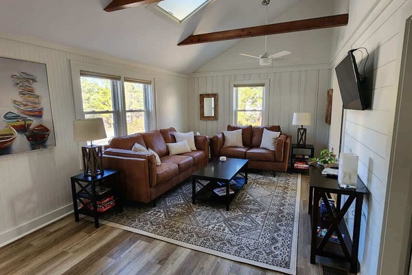 Gather and unwind. Our inviting living room features plush couch and loveseat, comfortable pillows, high ceilings, and abundance of natural light through skylights and windows.
