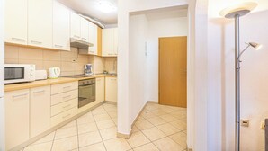 A modern kitchen with white cabinets, a microwave, a coffee maker, and a stove. - C apt w Terrace & sea View, 4 min Walk to Beach (Podstrana)