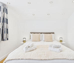 Una camera d'albergo ordinata con un letto, due comodini e una testiera.