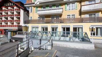 Un hotel a più piani con balconi, un ingresso in vetro e una rampa di accesso.