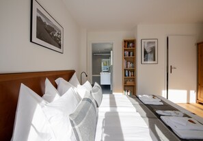 Une chambre d’hôtel avec un lit, une table de chevet, une bibliothèque et un tableau encadré au mur.