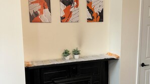 A room with a black cabinet, a white door, and three abstract paintings on the wall. - Outstanding spacious 2-bedroom Apt in downtown Cincinnati with many amenities (Cincinnati)